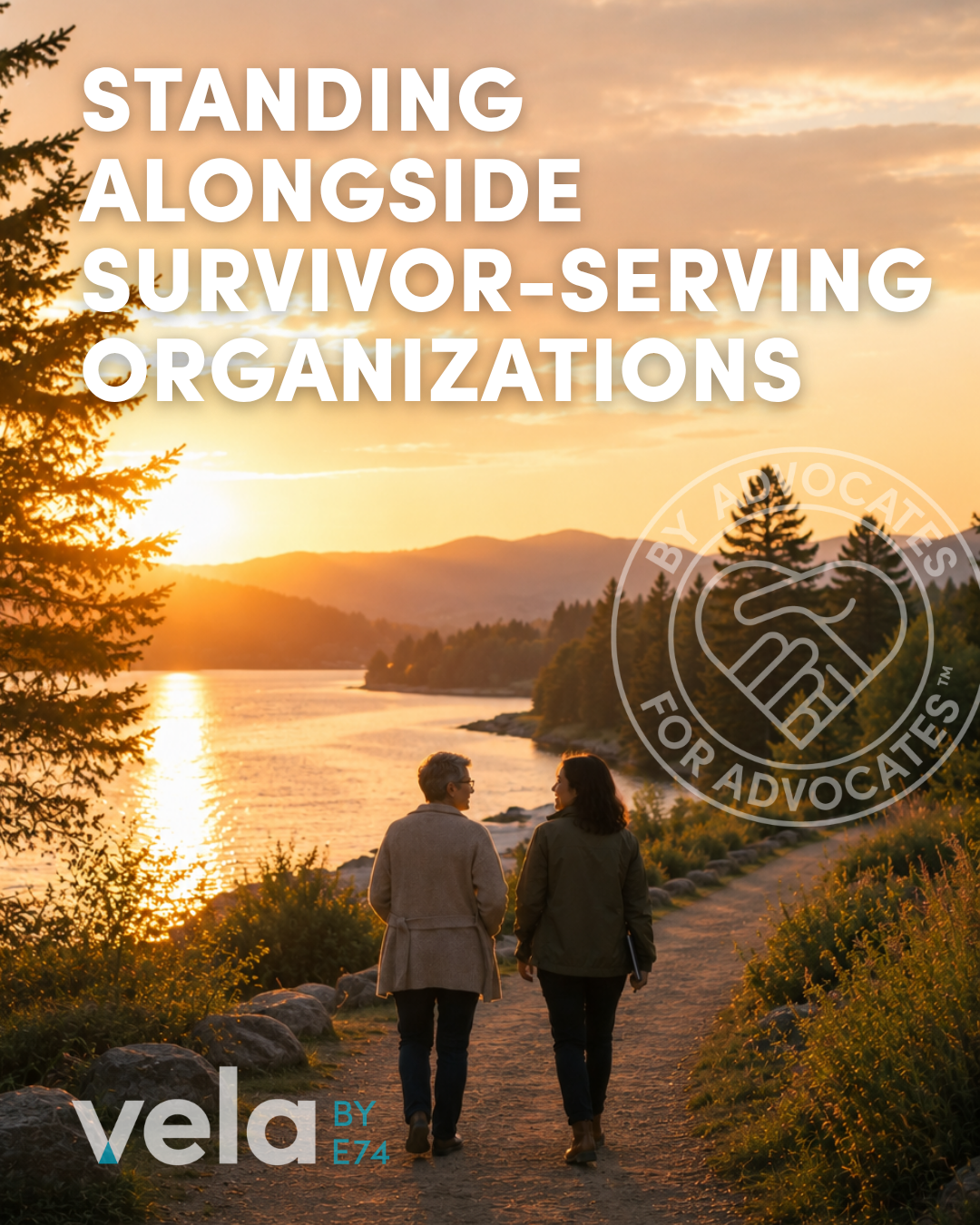 Two people standing alongside one another on a path before a sunset